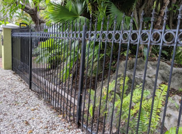 Pagar besi dengan aksen paku-paku di tiangnya